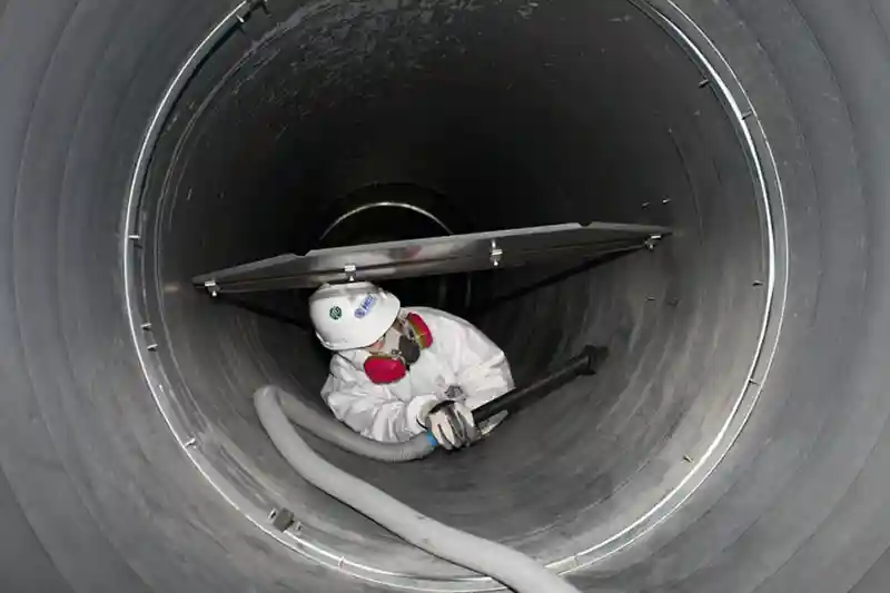 BELFOR technician cleaning inside of air conditioning duct